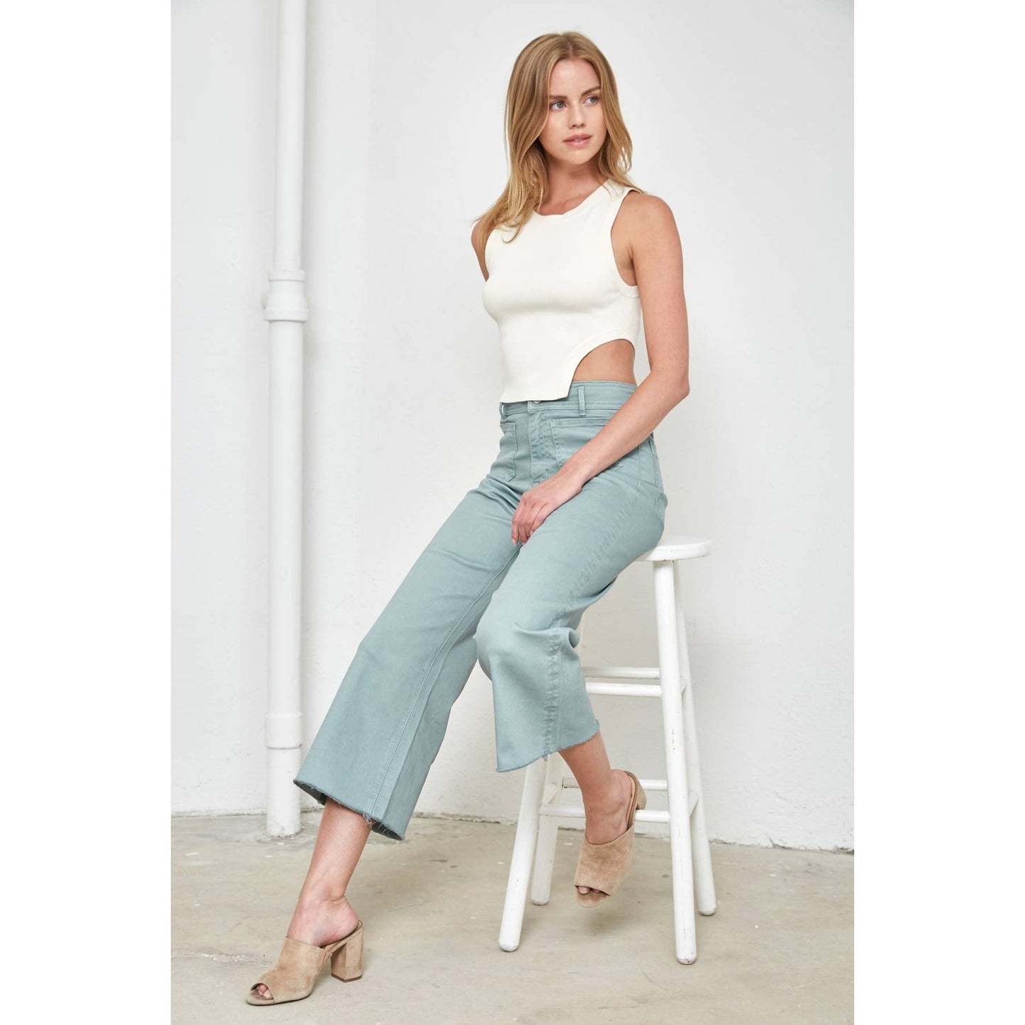Mint Green Cropped Wide Leg Pants on a model who is sitting down.